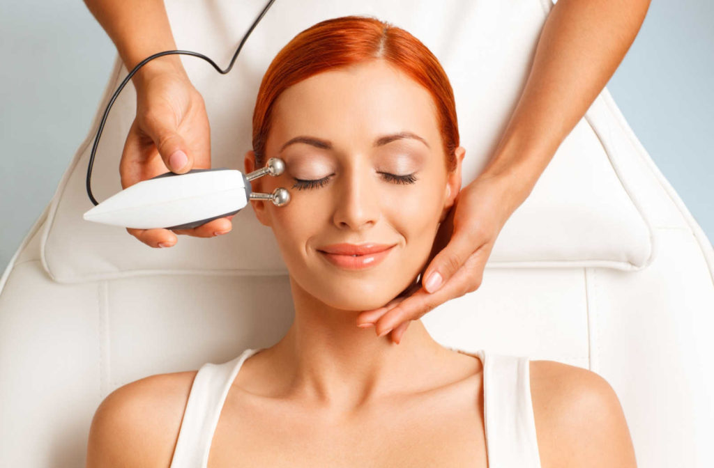 A woman has radiofrequency treatment applied next to her right eye.