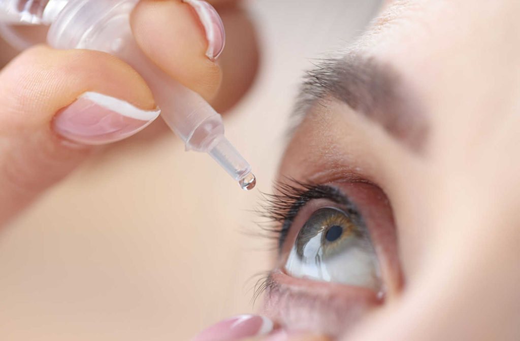 A woman uses artificial tear eye drops to lubricate dry eyes and help maintain moisture on the outer surface of the eyes.