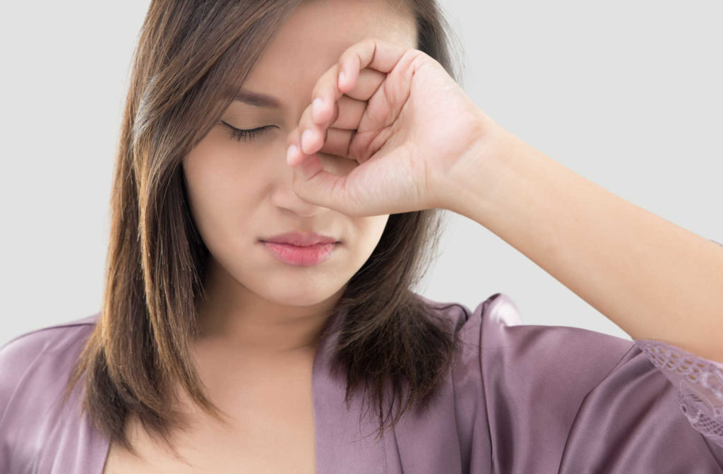 A woman in a purple robe woke up with irritated and itchy eyes.