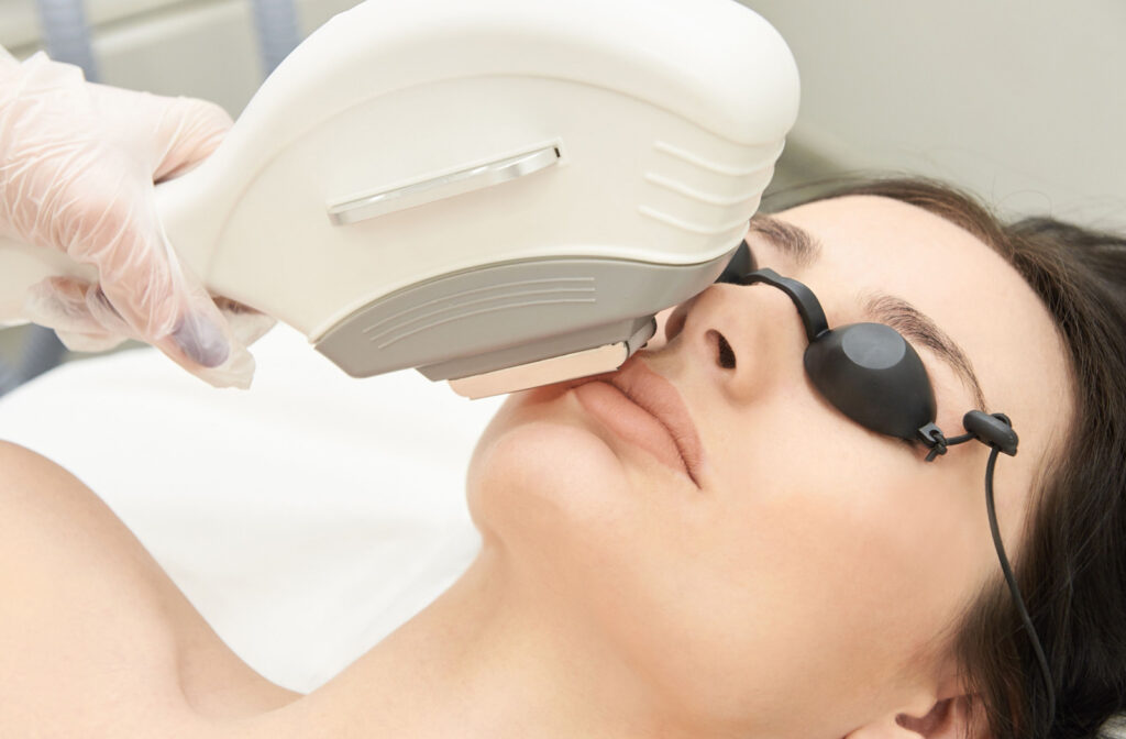 Close-up of a woman receiving an IPL Photofacial Treatment from an optometrist using a specialized equipment.